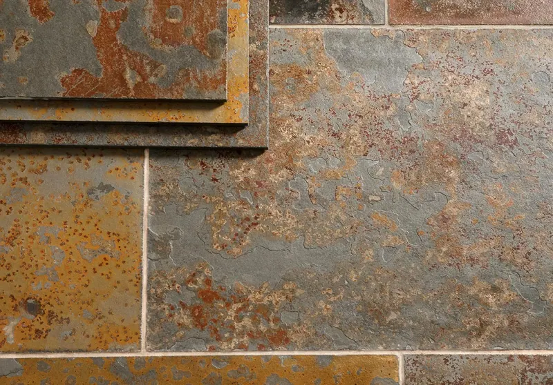 Detalle de palmetas de piedra pizarra con tonos grises, ocres y oxidados