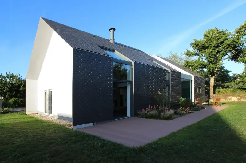 Casa contemporánea con pequeñas piezas de pizarra oscura en fachada y techo inclinado