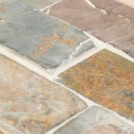 Detalle de piedra pizarra con tonos grises y oxidados y juntas claras
