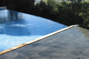 piso exterior de piscina revestida con pizarra negra